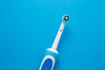 Smart electric toothbrush on a blue background close-up. Nozzle for brushing teeth.