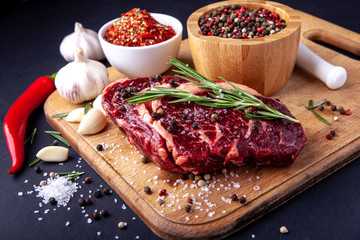 Fresh steak with a set of spices on a cutting board