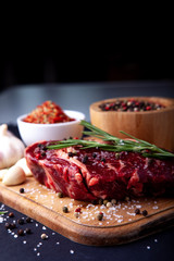 Fresh steak with a set of spices on a cutting board