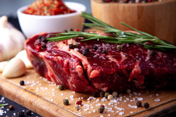 Fresh steak with a set of spices on a cutting board