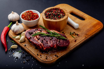 Fresh steak with a set of spices on a cutting board