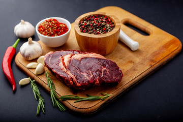 Fresh steak with a set of spices on a cutting board