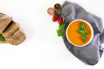 Homemade cream soup made of tomatoes, basil, and cheese. Top view, copy space