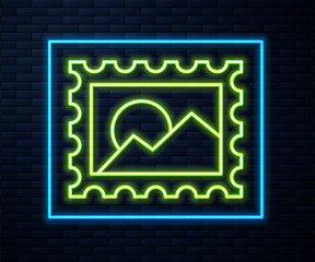 Glowing neon line Postal stamp icon isolated on brick wall background.  Vector Illustration