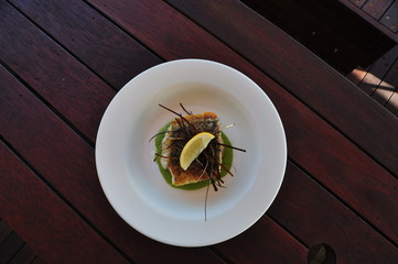 Crispy Skinned Barramundi on a white plate - top view