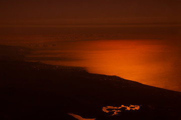 Photo from the plane with seaside in orange color. Mystic view from above. Meditarian sea.