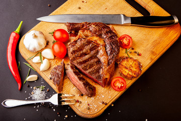 Fresh juicy ribeye steak with a set of spices on a cutting board
