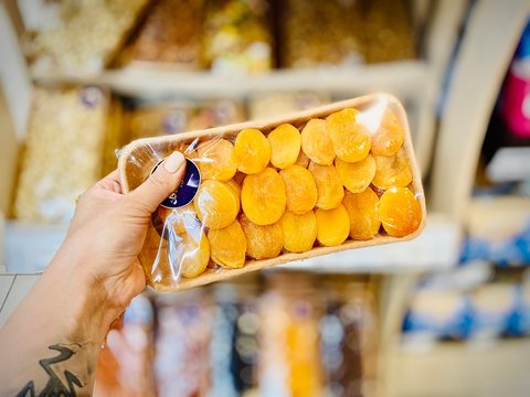 Different nuts and dried fruits in the package in the supermarket. A close-up. Mobile photo.