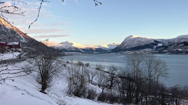 View at &Oslash;rsta In More og Romsdal Norway. In the winter sun is showing and cars driving by. Fjord view and sky is blue.