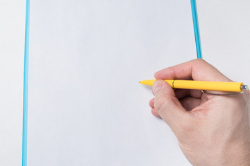 Male hand with pen on a blank sheet of paper . Man puts signature on paper. Close up