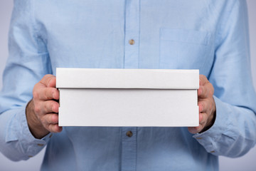 Male hands holding a cardboard box. Close up. Front view. Express delivery. Postman brought parcel.