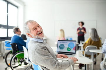 Portrait of senior man attending computer and technology education class.