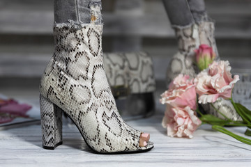 Luxury female high heel shoes made from snake skin worn by a woman