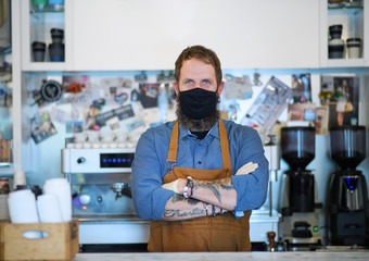 Barista with face mask in coffee shop, lockdown, quarantine, coronavirus, back to normal concept.