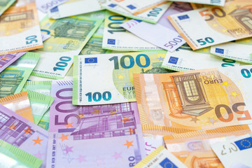 European currency lies on the table. Banknotes one hundred, two hundred, fifty, five hundred euros are scattered in a chaotic manner. Blank for design, background. Side view.