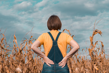 Rear view of corn farmer looking at her cornfield