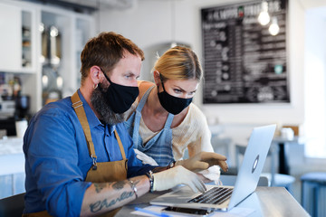 Coffee shop owners with face masks, lockdown, quarantine, coronavirus, back to normal concept.