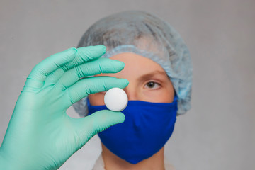 A teenager is holding a white tablet in his hand.