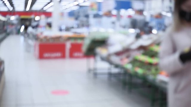 supermarket with shelves for products internal defocused blurred background. people in masks, due to a coronovirus infection