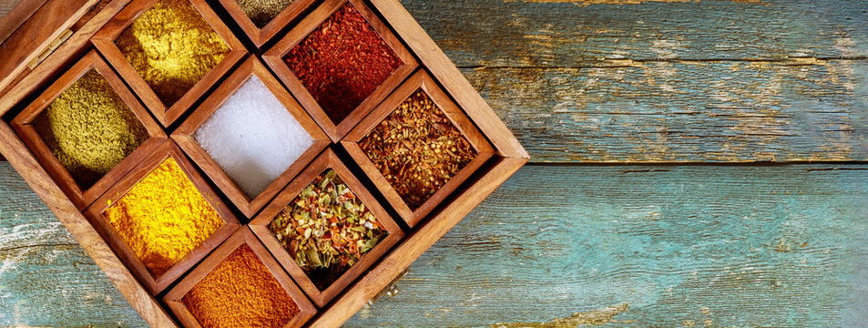 Top view of wooden tray filled with full of ground colorful spices - Powered by Adobe