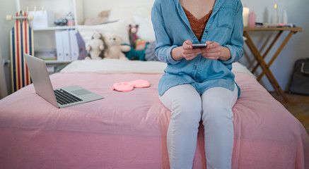 Obraz premium Midsection of young girl with laptop and smartphone indoors, internet abuse concept.