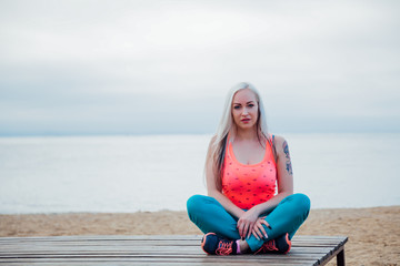 the girl is engaged in fitness on the beach