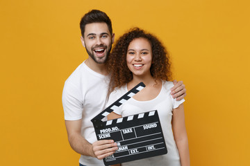 Cheerful young couple two friends european guy african american girl in white t-shirts posing...