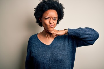 Fototapeta na wymiar Young beautiful African American afro woman with curly hair wearing casual sweater cutting throat with hand as knife, threaten aggression with furious violence