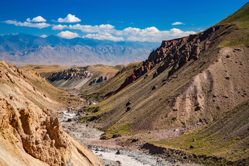 Beautiful landscape. Hilly area. The sandy gorge. View of peaks. Cloudy blue sky.