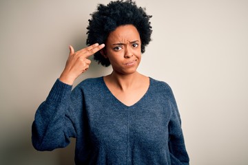 Young beautiful African American afro woman with curly hair wearing casual sweater Shooting and killing oneself pointing hand and fingers to head like gun, suicide gesture.