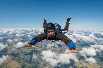 Tuinposter Male skydiver falling above the clouds © vladimirzhoga