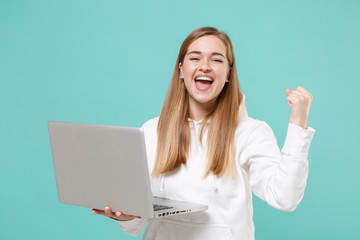 Happy young woman girl in casual white hoodie posing isolated on blue turquoise background studio...