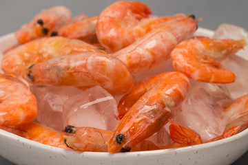 Frozen shrimp with ice in bowl.