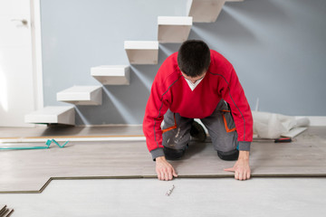 repairman laying flooring