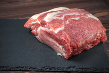 Raw pork chop steak on a black board. Pork antricot