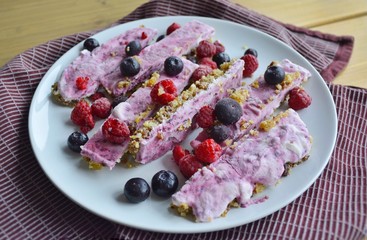 Homemade pink frozen yogurt bars with raspberries and blueberries. Snack for the summer days