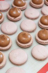 Making chocolate macaroons. Filling shells with chocolate ganache. Selective focus.