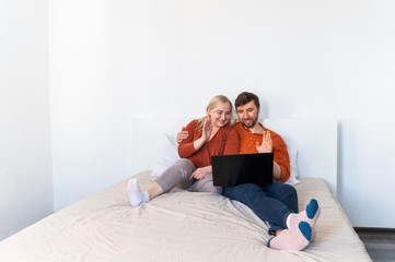 Smiling young adult couple using laptop and waving their hands motion blur effect