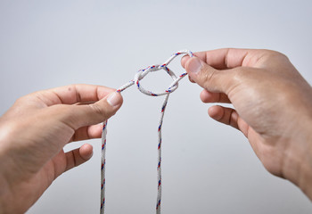 hands making a knot on white background