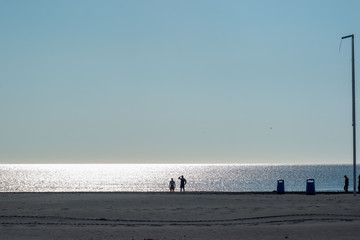 Fototapeta na wymiar Sparkling sea,blue sky silhouettes of people