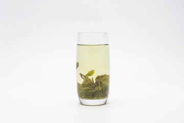 The long glass holds fresh green tea, isolated against a white background.