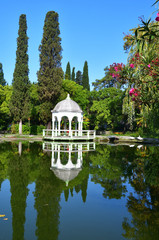 New Athos, Abkhazia. White gazebo on the pond in the city Park in sunny day