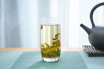 A long glass filled with fresh green tea.