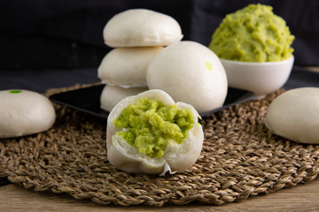 White buns on a black plate on a brown wooden floor.