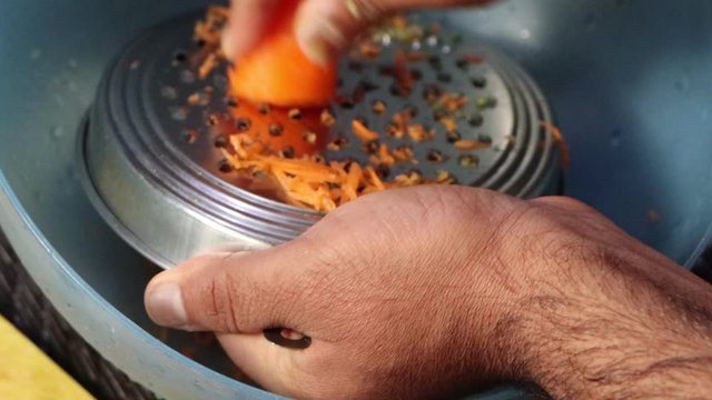 Grating of carrots on Indian grater for carrot halwa, Indian dessert, cooking preparations