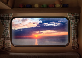 View from window camper of stunning dusk over calm ocean