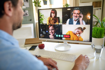 Unrecognizable man having video call on computer at home.