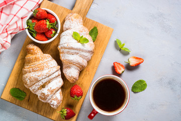 Croissant with fresh berries and cup of coffee.