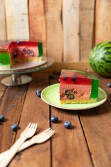 Torte als Melone auf einem Tisch aus Holz mit Götterspeise und Creme