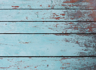 The surface of old dry wooden horizontal boards of blue color. The paint on the surface is dry and...
